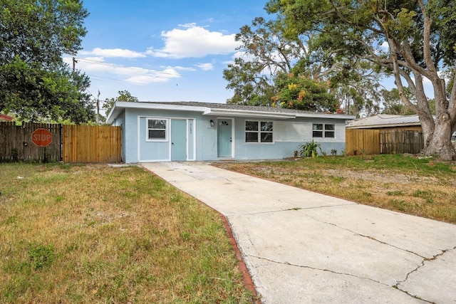 ranch-style house featuring stucco siding, a front lawn, and fence