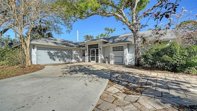 ranch-style house featuring stucco siding, concrete driveway, and a garage