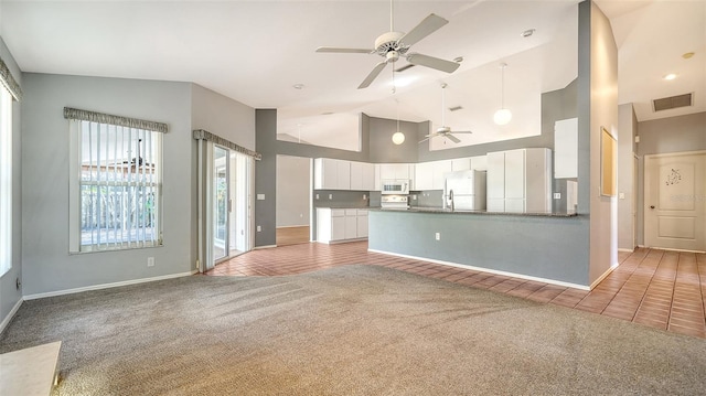 unfurnished living room with visible vents, light carpet, high vaulted ceiling, a ceiling fan, and light tile patterned floors