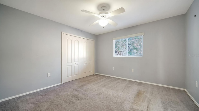 unfurnished bedroom featuring a closet, baseboards, carpet, and ceiling fan