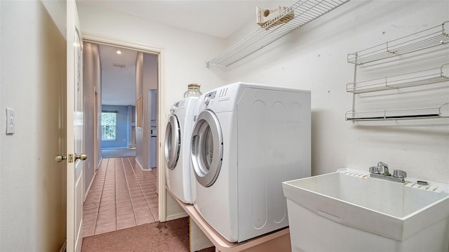 laundry area with a sink, separate washer and dryer, carpet, tile patterned flooring, and laundry area