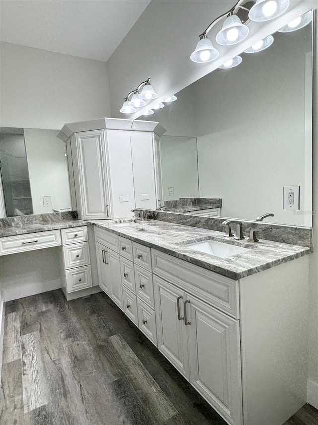 full bathroom with double vanity, wood finished floors, and a sink