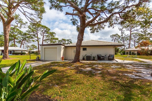 411 S Oxford Dr Unit 411, Nokomis, FL 34275 - view of front of property featuring a front yard, central AC unit, an attached garage, stucco siding, and concrete driveway