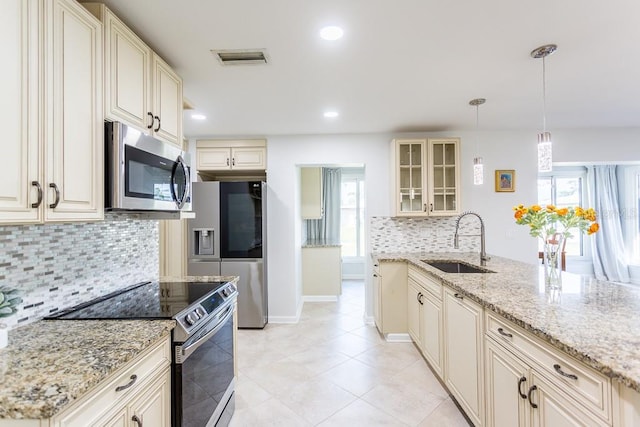 411 S Oxford Dr Unit 411, Nokomis, FL 34275 - kitchen featuring visible vents, cream cabinetry, a sink, appliances with stainless steel finishes, and glass insert cabinets