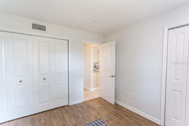 411 S Oxford Dr Unit 411, Nokomis, FL 34275 - unfurnished bedroom with a closet, visible vents, baseboards, and wood finished floors