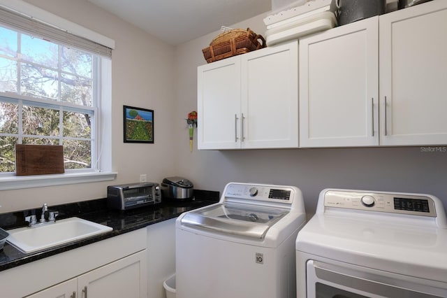 washroom featuring a sink, cabinet space, independent washer and dryer, and a wealth of natural light