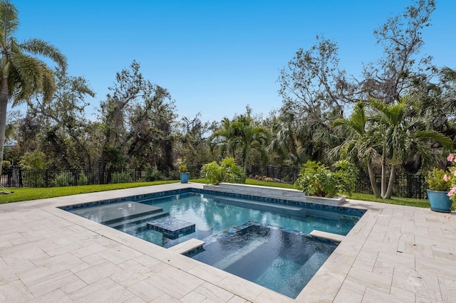 view of pool featuring a patio, a fenced backyard, and a pool with connected hot tub