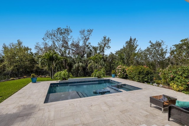 view of pool featuring a patio area, fence, and a pool with connected hot tub