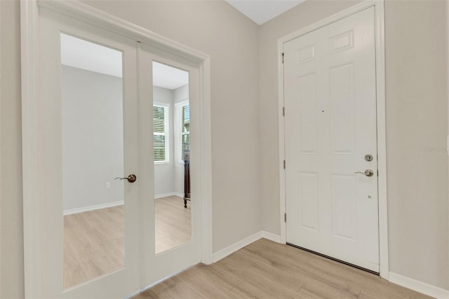 foyer featuring light wood-style flooring and baseboards