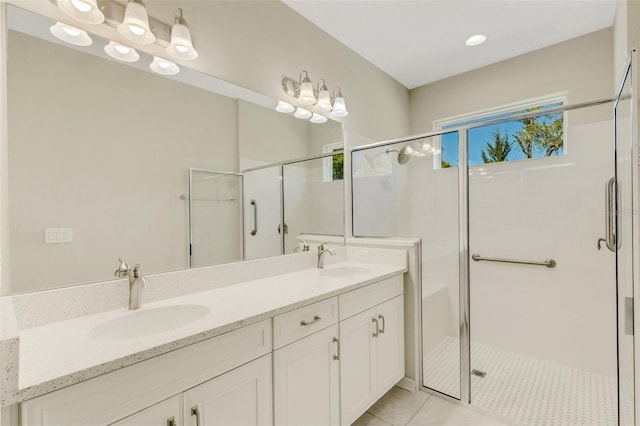 bathroom with a sink, a stall shower, and double vanity