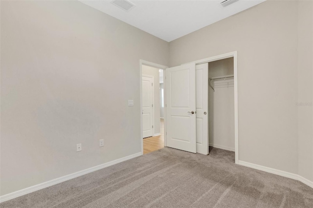 unfurnished bedroom featuring a closet, visible vents, baseboards, and carpet floors