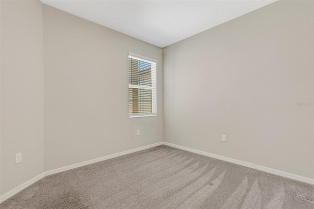 carpeted empty room with baseboards