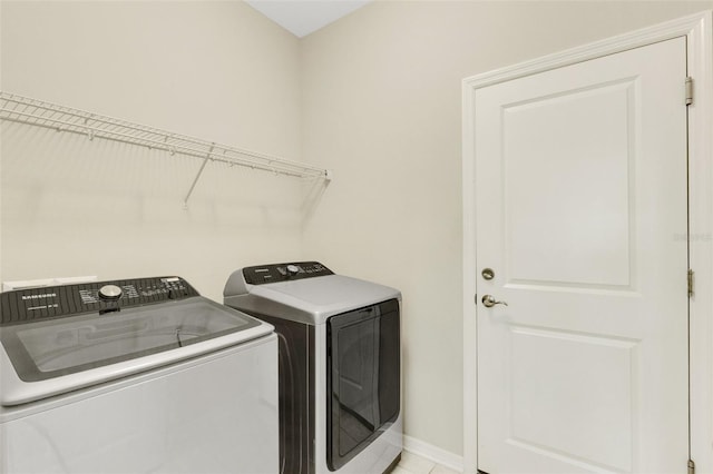 laundry area featuring laundry area, washing machine and dryer, and baseboards