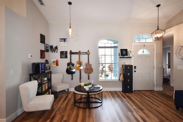 foyer featuring visible vents, baseboards, wood finished floors, and a chandelier