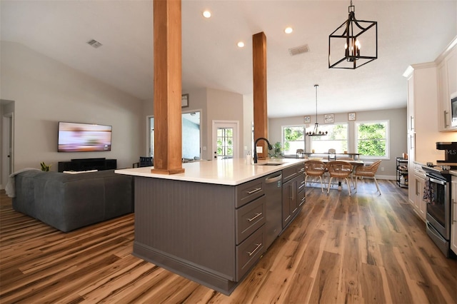 kitchen featuring visible vents, a sink, stainless steel appliances, white cabinets, and a chandelier