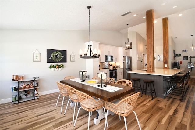 dining space with baseboards, visible vents, recessed lighting, light wood-type flooring, and a chandelier