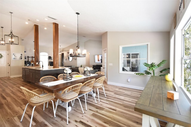 dining area featuring baseboards, light wood-style floors, visible vents, and a chandelier