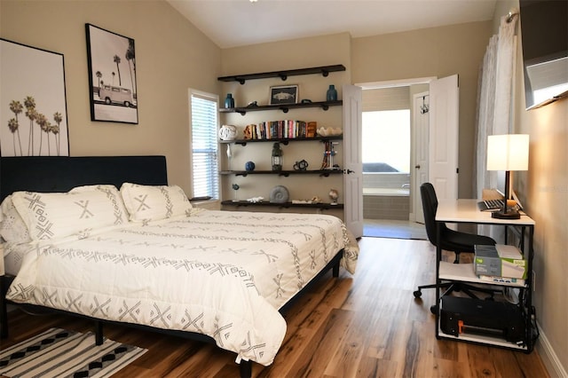 bedroom featuring wood finished floors, baseboards, and ensuite bathroom