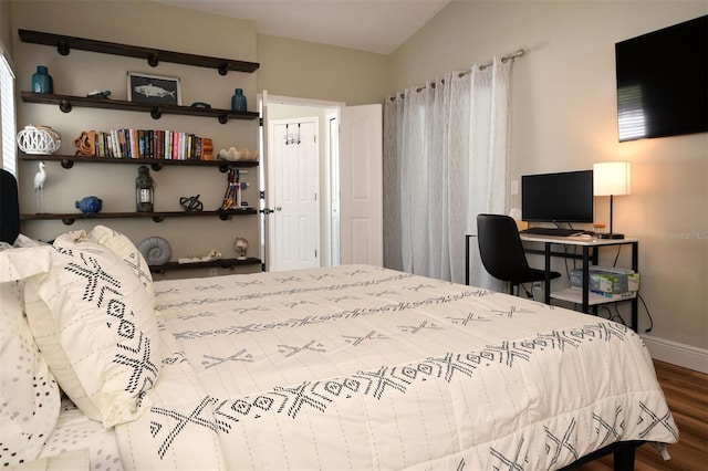 bedroom featuring vaulted ceiling, wood finished floors, and baseboards