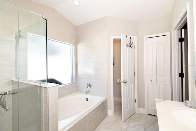 full bath with a garden tub, marble finish floor, a closet, a shower stall, and vaulted ceiling