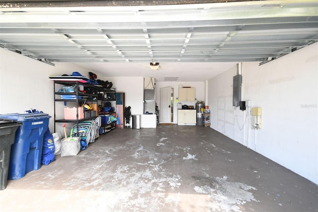 garage with electric panel, washing machine and dryer, and a garage door opener