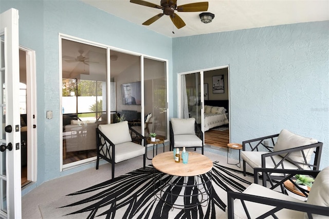 exterior space featuring ceiling fan and a textured wall