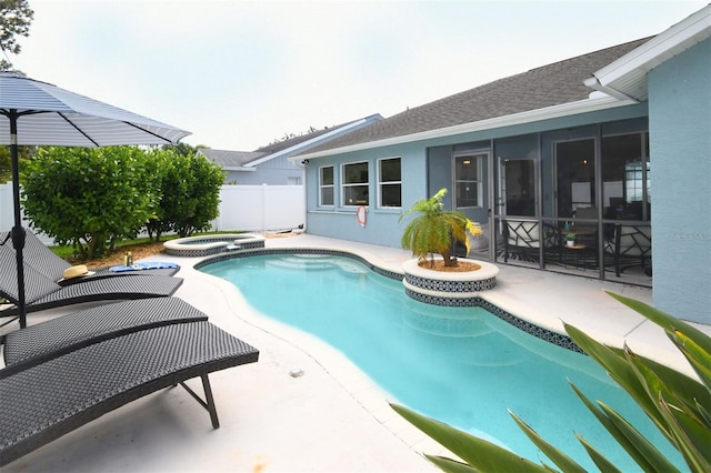 view of pool featuring a patio, fence, a pool with connected hot tub, and a sunroom