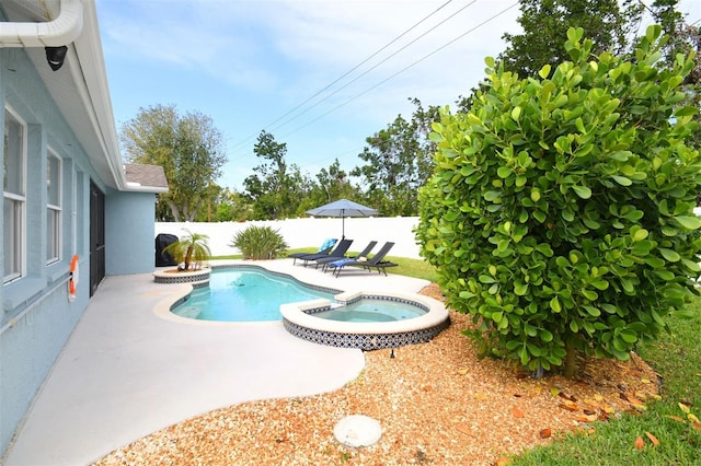 view of pool with a pool with connected hot tub, a patio area, and a fenced backyard