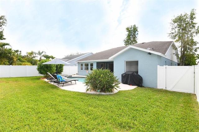 rear view of property featuring a fenced in pool, a lawn, stucco siding, a fenced backyard, and a patio