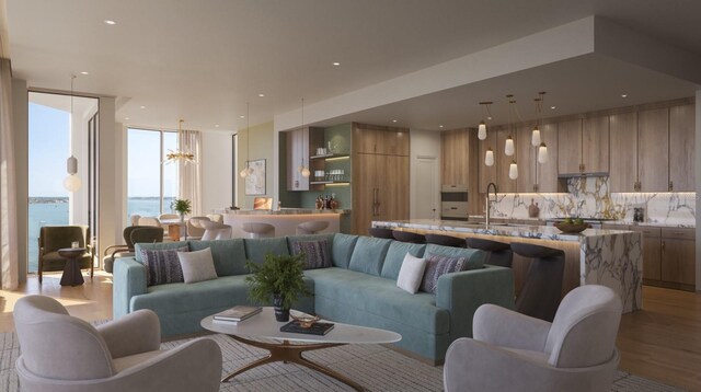 living area with recessed lighting, a notable chandelier, light wood-style flooring, and a wall of windows