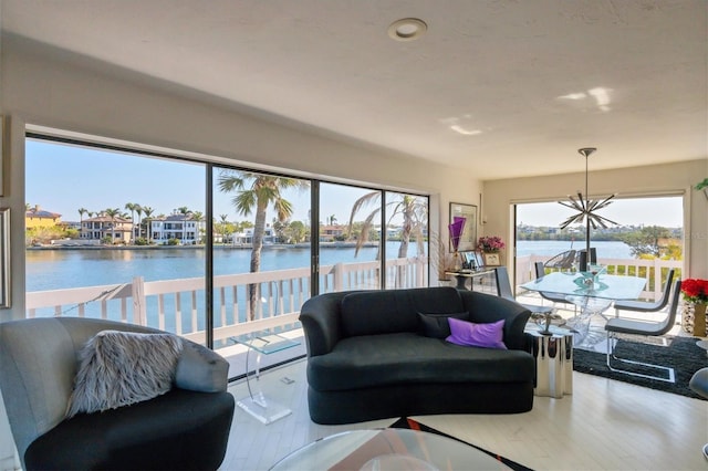 living room featuring an inviting chandelier, wood finished floors, and a water view