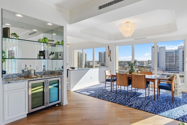 35 Watergate Dr Unit 1402, Sarasota, FL 34236 - dining room with a city view, beverage cooler, ornamental molding, wood finished floors, and wet bar