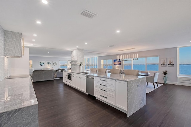 kitchen with visible vents, white cabinetry, a sink, dishwasher, and open floor plan