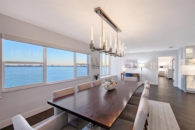 dining room with dark wood finished floors, a notable chandelier, and baseboards