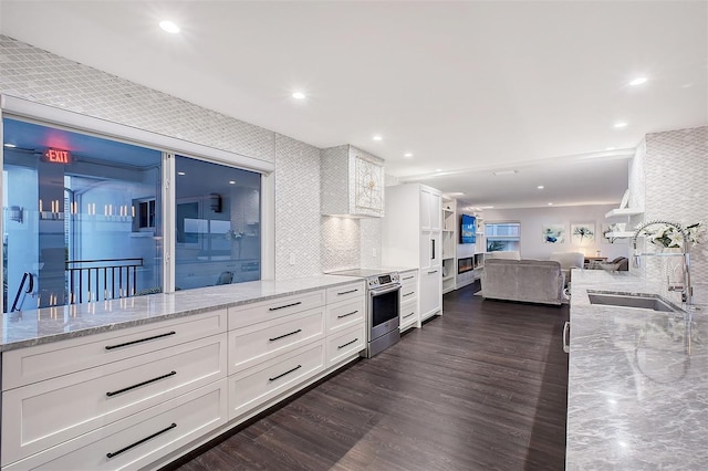 kitchen with a sink, stainless steel range with electric stovetop, white cabinets, and dark wood finished floors