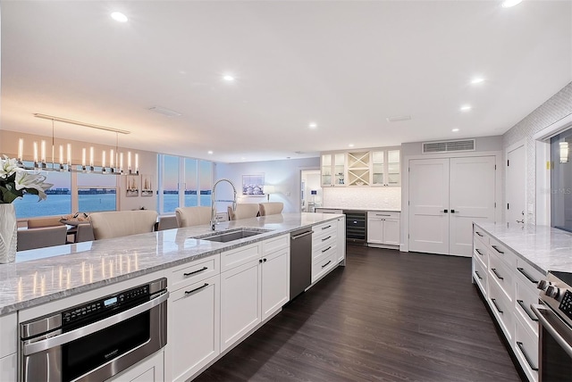 kitchen with visible vents, wine cooler, white cabinets, stainless steel appliances, and a sink