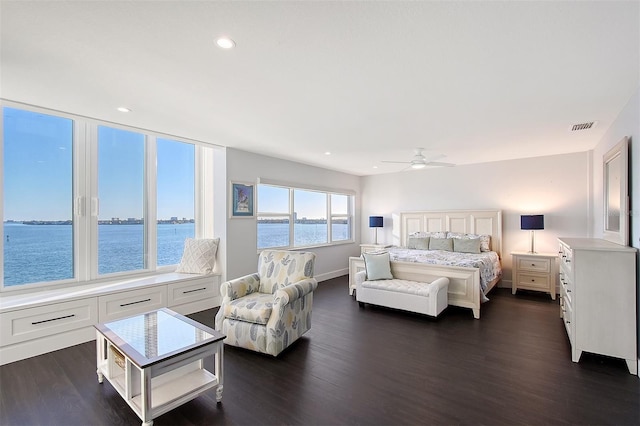 bedroom featuring recessed lighting, visible vents, a water view, and dark wood-type flooring