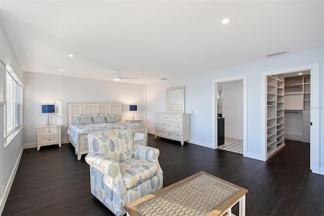 bedroom featuring baseboards, visible vents, recessed lighting, dark wood-style flooring, and a walk in closet