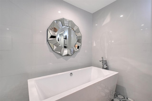 bathroom with a freestanding bath and tile walls