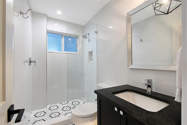 bathroom featuring vanity, decorative backsplash, a shower stall, tile walls, and toilet