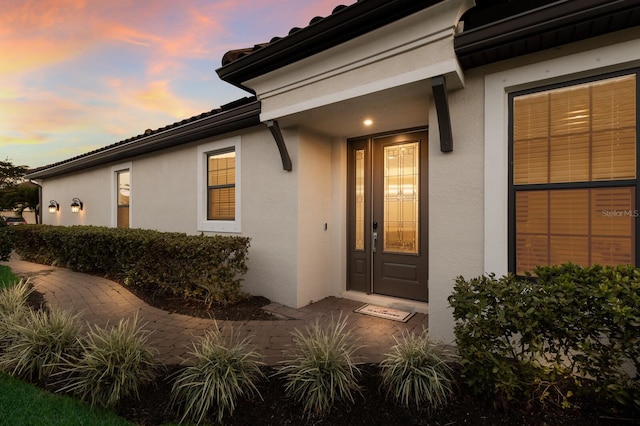 exterior entry at dusk with stucco siding