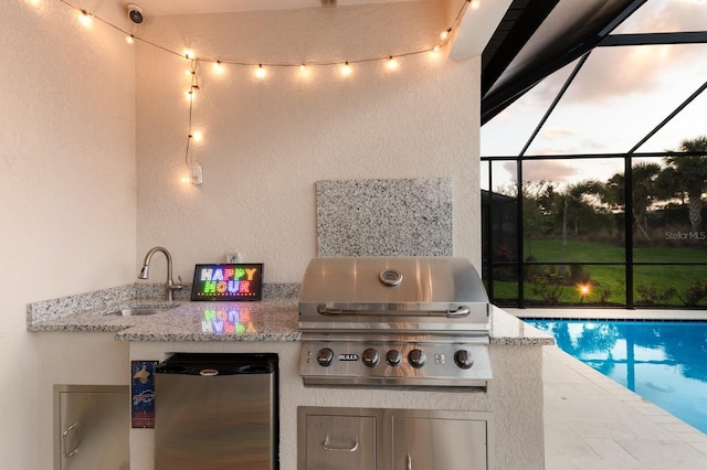 view of patio featuring a sink, a lanai, exterior kitchen, and grilling area