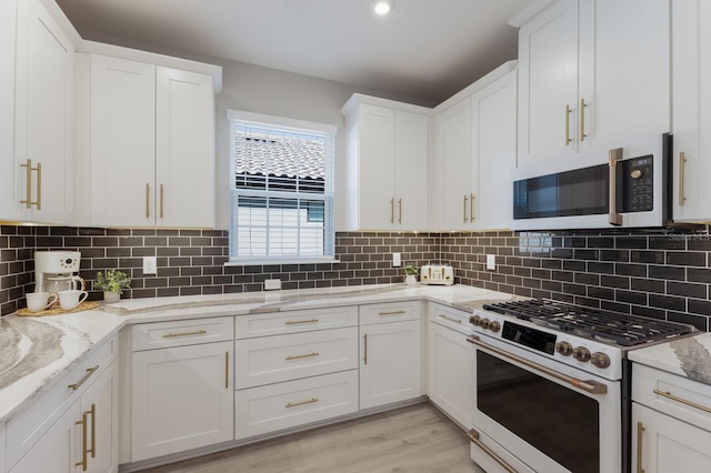 kitchen featuring white appliances, white cabinets, and tasteful backsplash