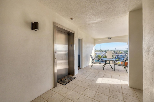 view of patio / terrace with elevator and a balcony