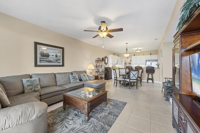 living area with light tile patterned floors and a ceiling fan