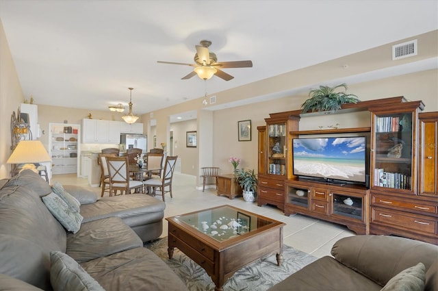 living area featuring light tile patterned floors, visible vents, and a ceiling fan