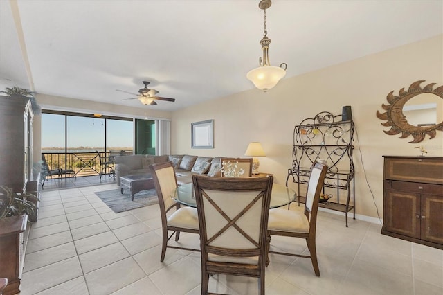 dining space with baseboards, light tile patterned flooring, and a ceiling fan