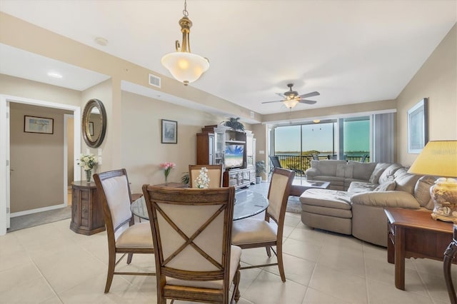 dining room with light tile patterned floors, visible vents, baseboards, and a ceiling fan