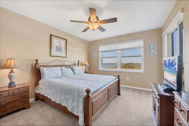 bedroom with light colored carpet, baseboards, and ceiling fan