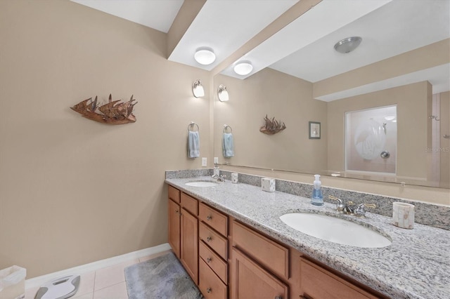 bathroom featuring a sink, baseboards, double vanity, and tile patterned flooring